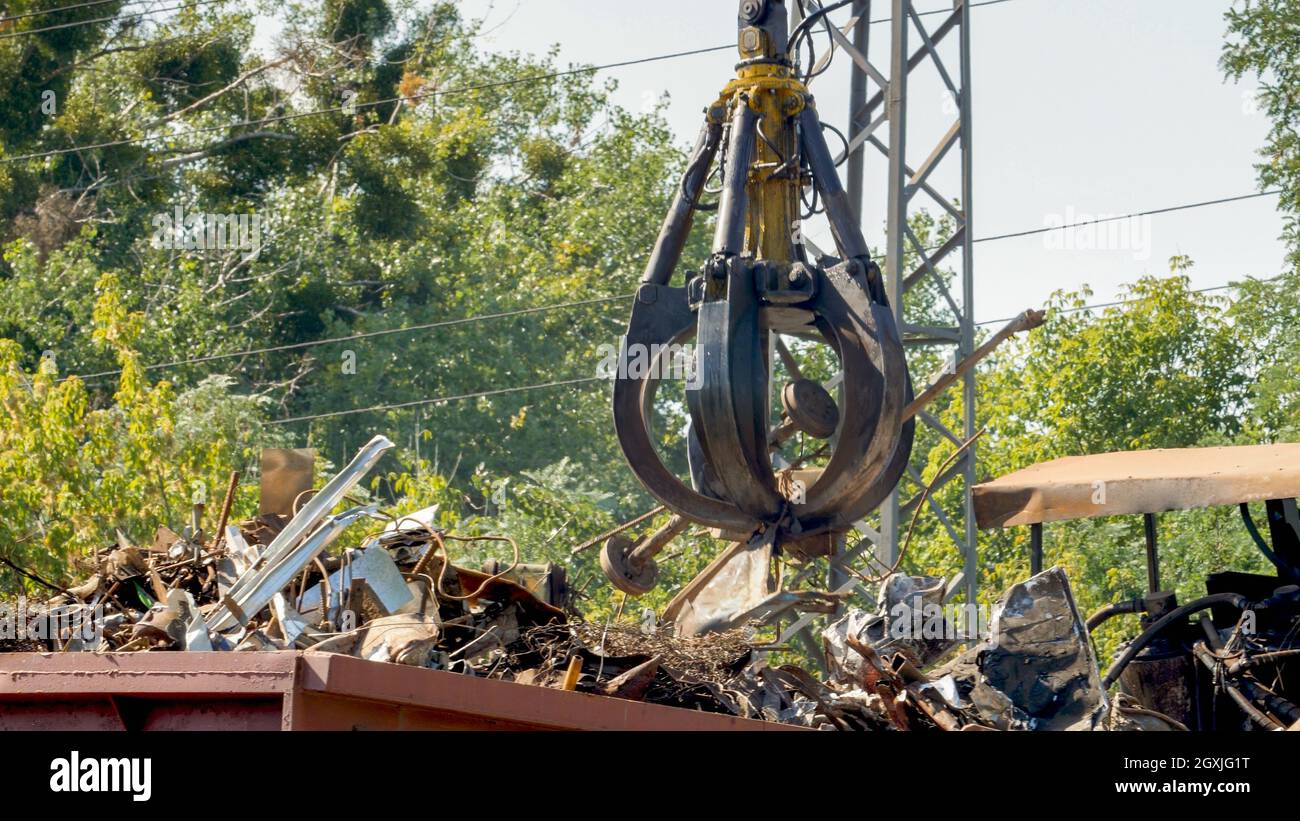 Foto der Metallklaue, die Metall auf dem Schrottplatz hebt Stockfoto