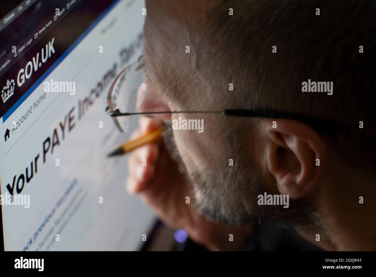 Mann, der die Internetseite von HM Revenue and Customs HMRC ansieht, um die Einkommensteuer zu überprüfen Stockfoto