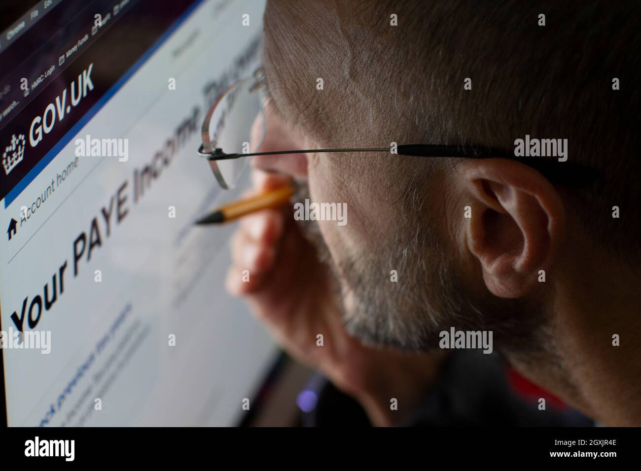 Mann, der die Internetseite von HM Revenue and Customs HMRC ansieht, um die Einkommensteuer zu überprüfen Stockfoto