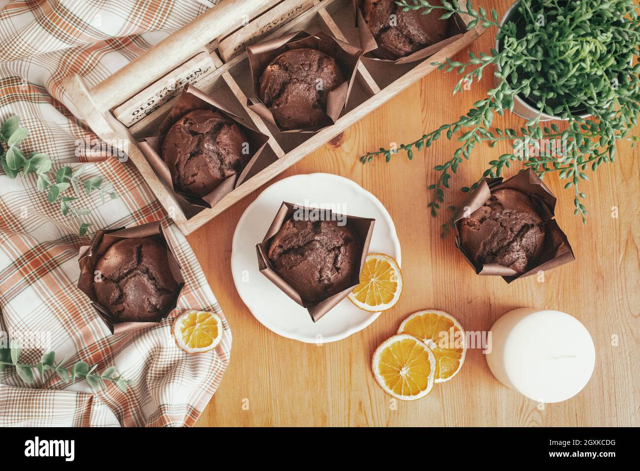 Blick von oben auf Schokolade und orangefarbene Muffins auf einem Holztisch Stockfoto