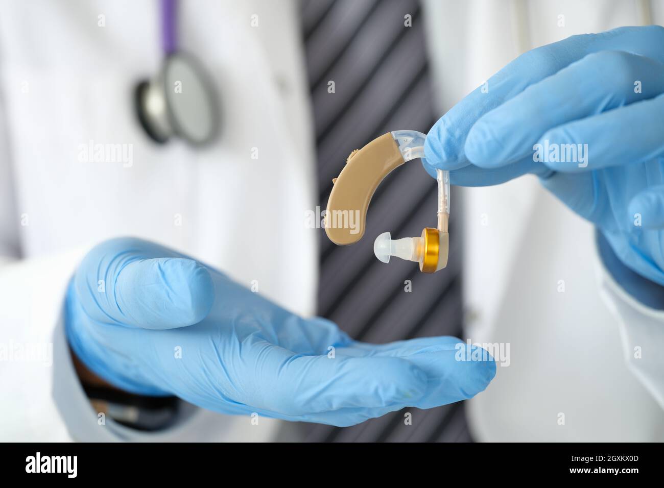 Arzt Otorhinolaryngologe, der Hörgeräte in der Nähe in den Händen hält Stockfoto