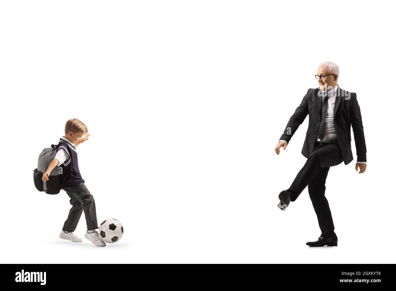 Schuljunge spielt Fußball mit einem Mann in einem Anzug isoliert auf weißem Hintergrund Stockfoto