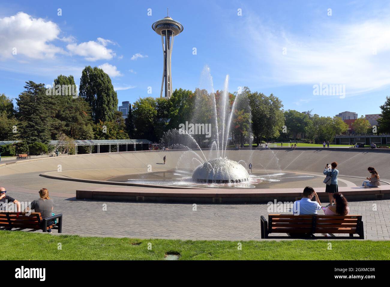 Touristen und Einheimische an einem sonnigen Tag im International Fountain und Space Needle im Seattle Center, Seattle, Washington. Stockfoto