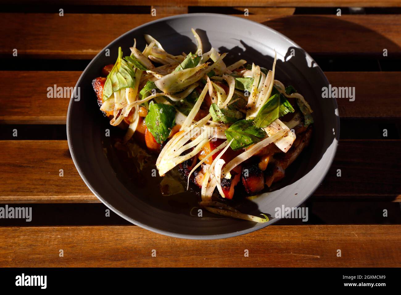 Holzgefeuerte, traditionelle Mangalitsa-Mitte, die Schweinekotelett mit sautiertem Fenchel, Pfirsichen und Basilikum in Ruthie's PDX geschnitten hat [siehe weitere Informationen] Stockfoto