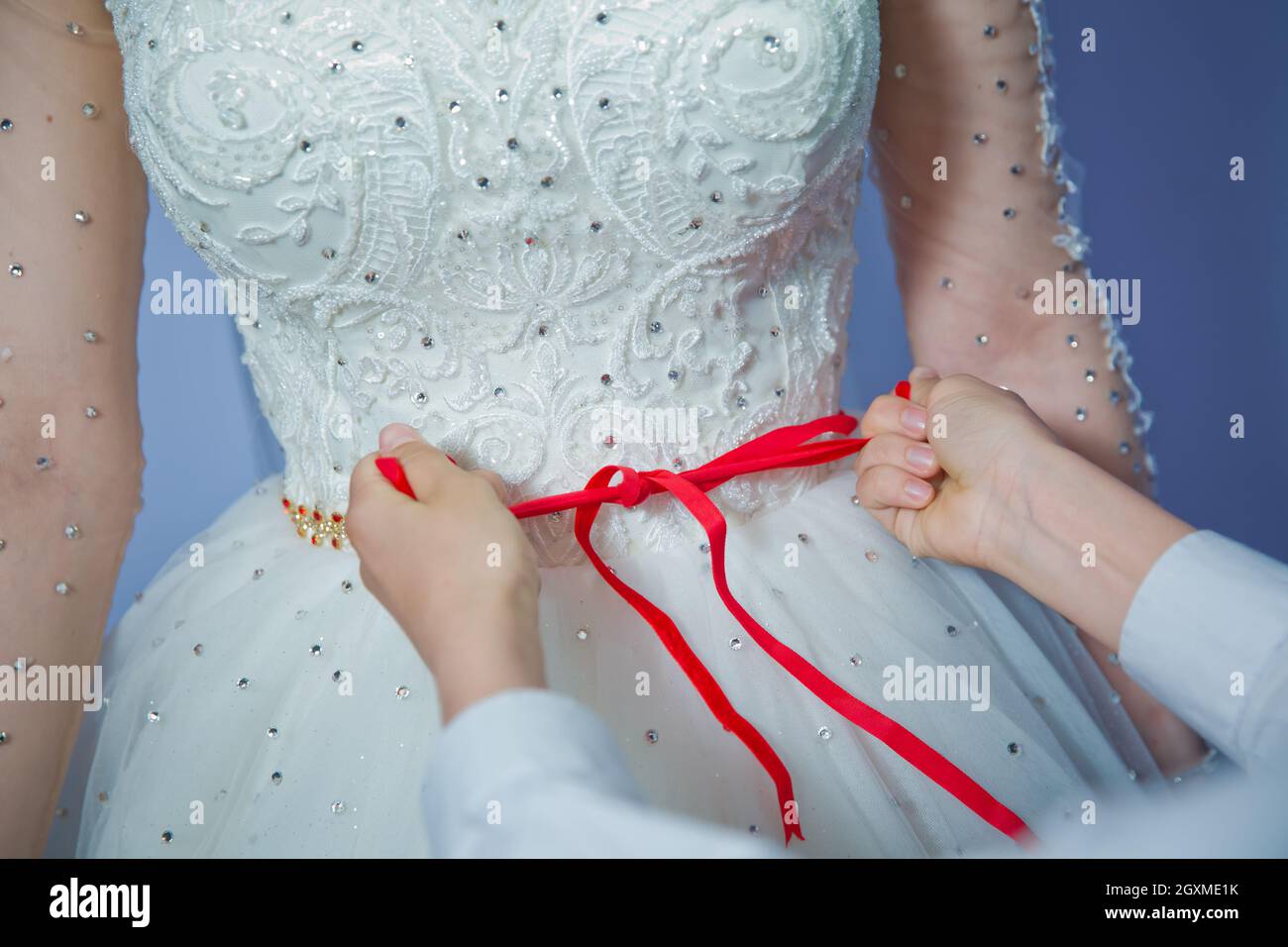 Verliere das Band am Bauch der Frau. Hochzeit . Brautjungfern schnürten die Brautleute. Schließen Sie das Band am Bauch der Frau. Schließen Sie das Band am Bauch Stockfoto