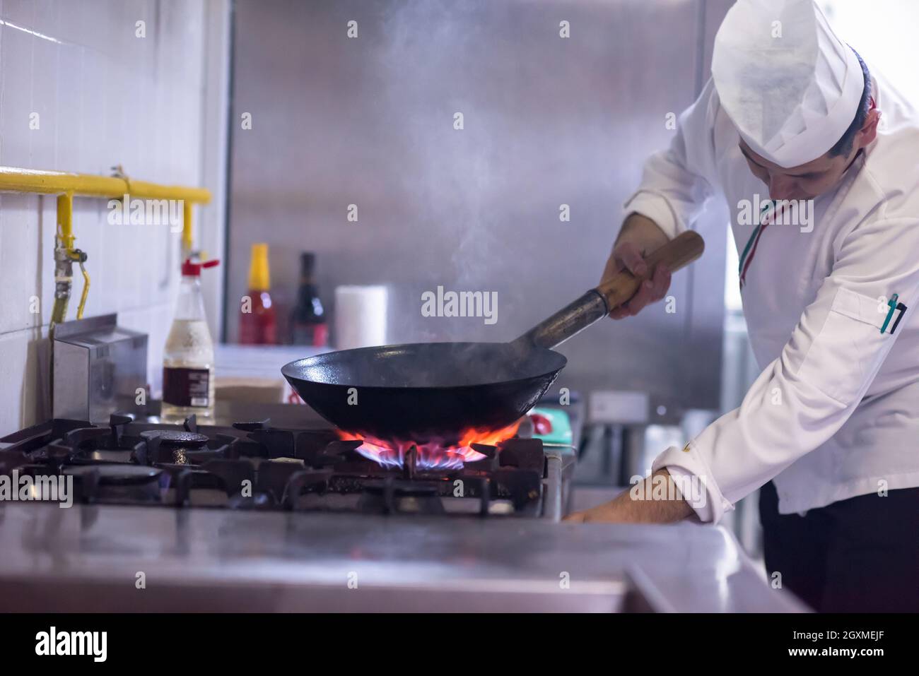 Chefkoch Kochen, Braten im Wok Pfanne. Verkauf und Essen Konzept Stockfoto