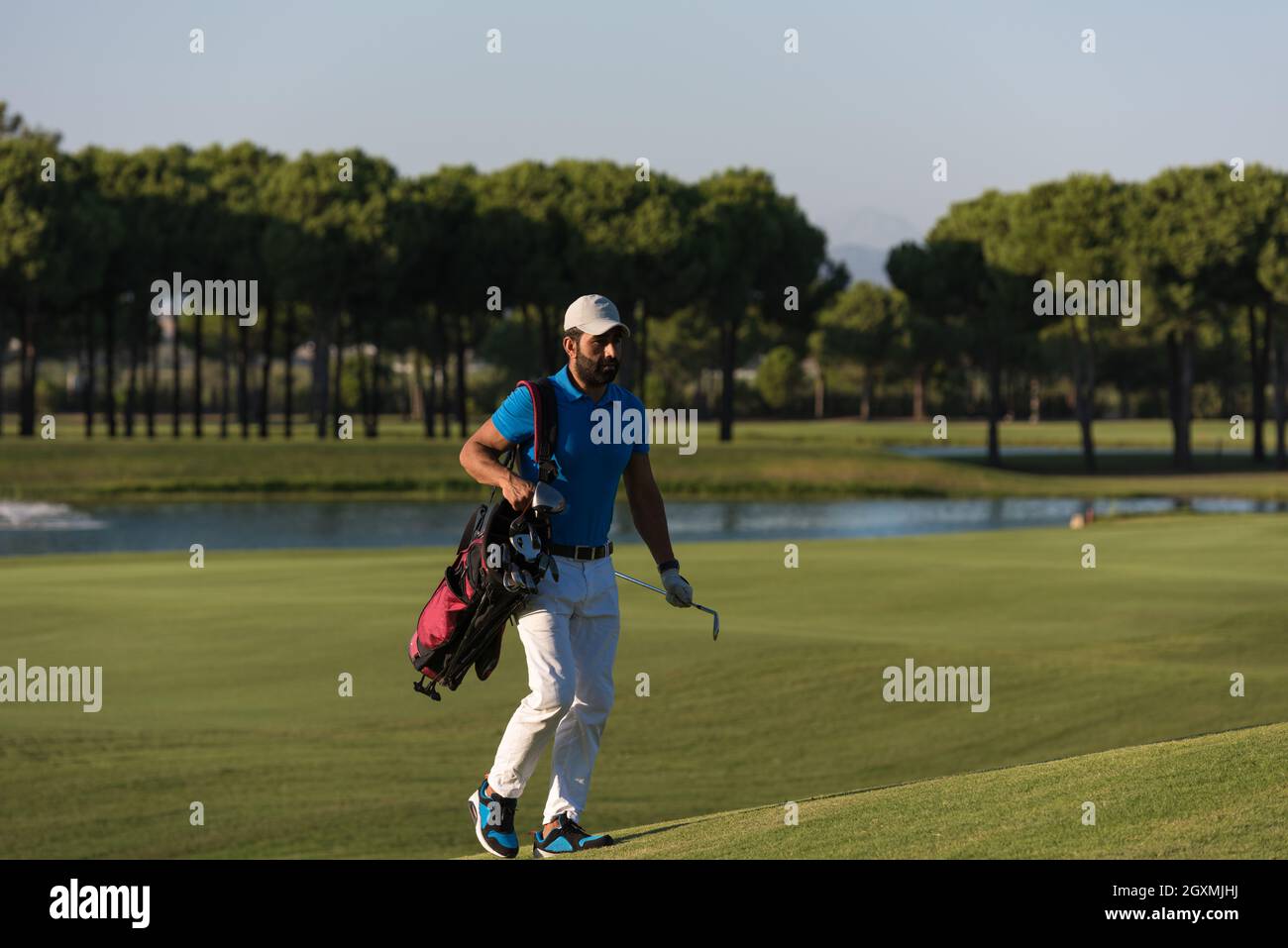 schöne orientalische Golfer Tragetasche und zu Fuß zum nächsten Loch am Golfplatz Stockfoto