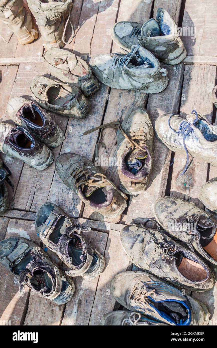 Schlamm koveerd schmutzige Schuhe auf einem Holzboden des Bootes Stockfoto