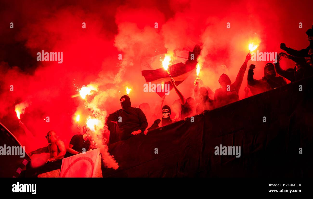 Fußball-Hooligans mit Maske halten Fackeln in Feuer, während Ihre Lieblingsmannschaft Unterstützung bei einem Spiel im Stadion Stockfoto