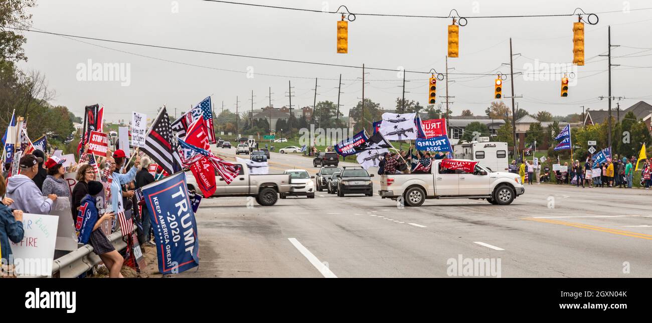 Howell, Michigan, USA. Oktober 2021. Die Republikaner protestieren, als Präsident Joe Biden Michigan besucht, um seinen Build Back Better Plan zu fördern. Ein Lastwagen voller junger Männer winkte Trump-Banner und Flaggen mit Sturmwaffen. Kredit: Jim West/Alamy Live Nachrichten Stockfoto