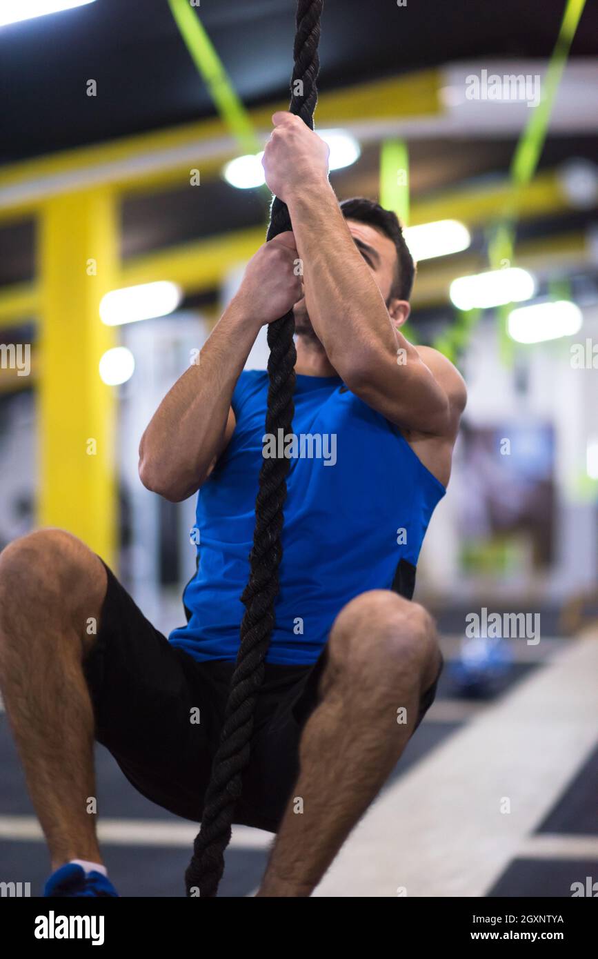 Junge muskulöse Mann tun Seil klettern in Cross Fitness Gym Stockfotografie  - Alamy
