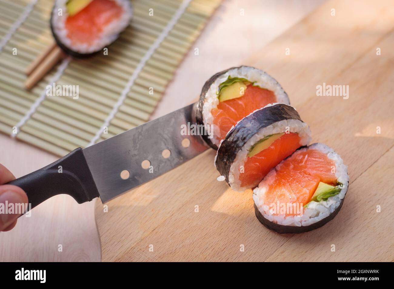 Japanische Küche, Sushi. Lebensmittelherstellung. Die Zusammensetzung von Sushi, natürliches Licht. Appetitliche Farben. Stockfoto