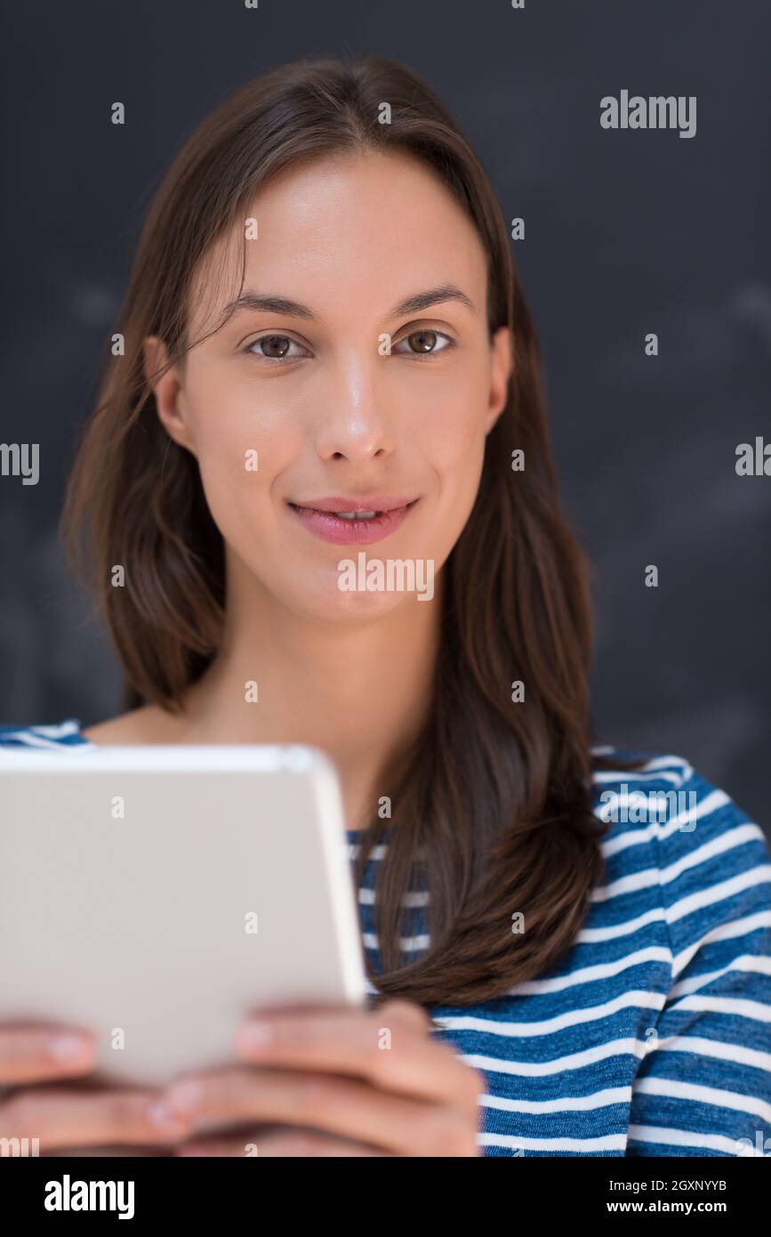 Glückliche junge Frau mit Tablet-PC vor kreidezeichnung Board Stockfoto