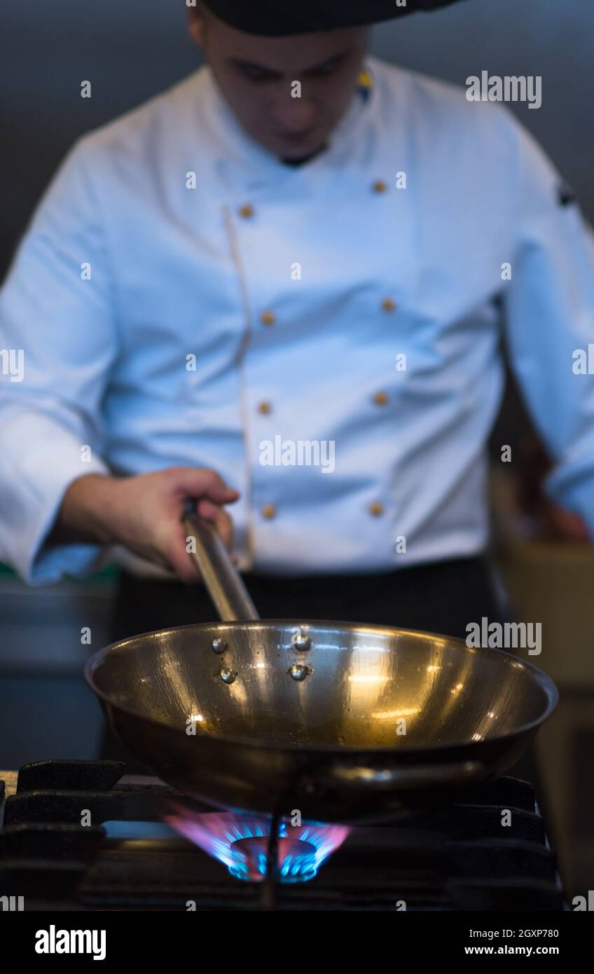 Chefkoch Kochen, Braten im Wok Pfanne. Verkauf und Essen Konzept Stockfoto