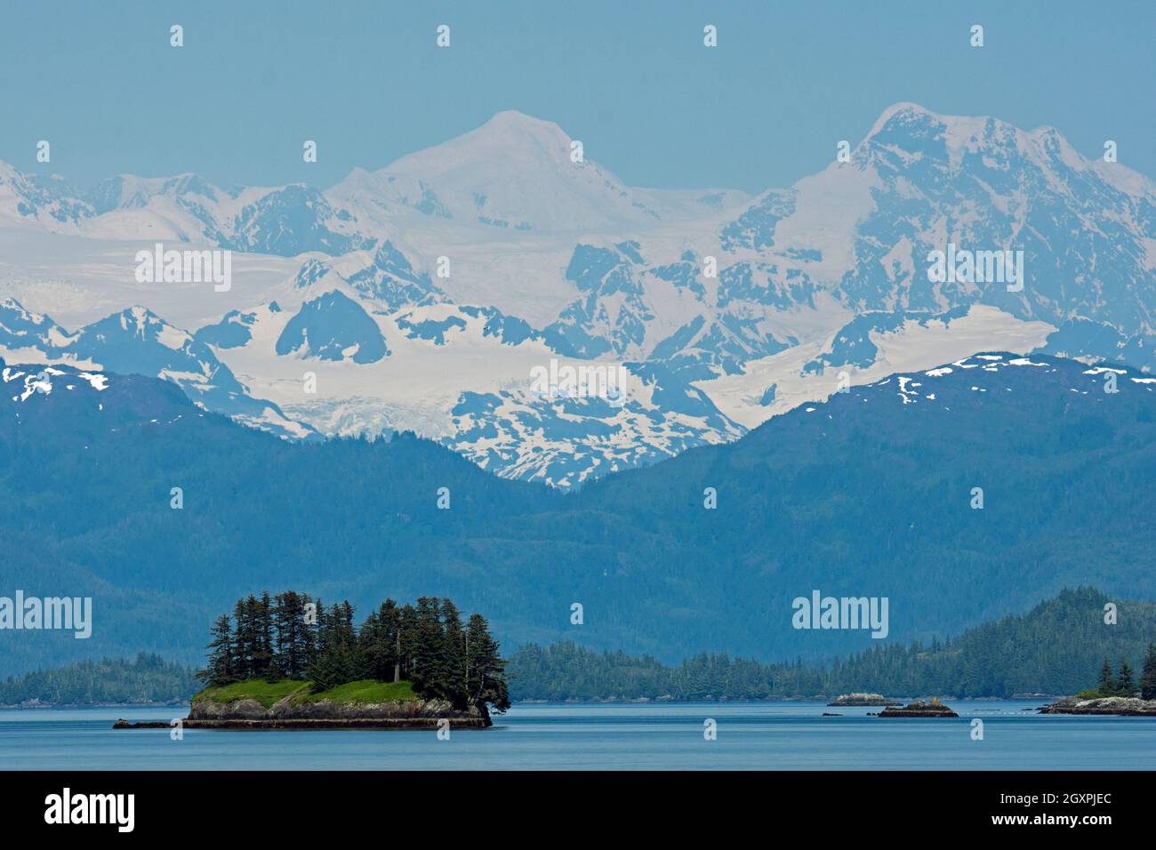Inselchen und verschneite Landschaft während der Sommerüberquerung des Prince William Sound, Alaska, USA Stockfoto