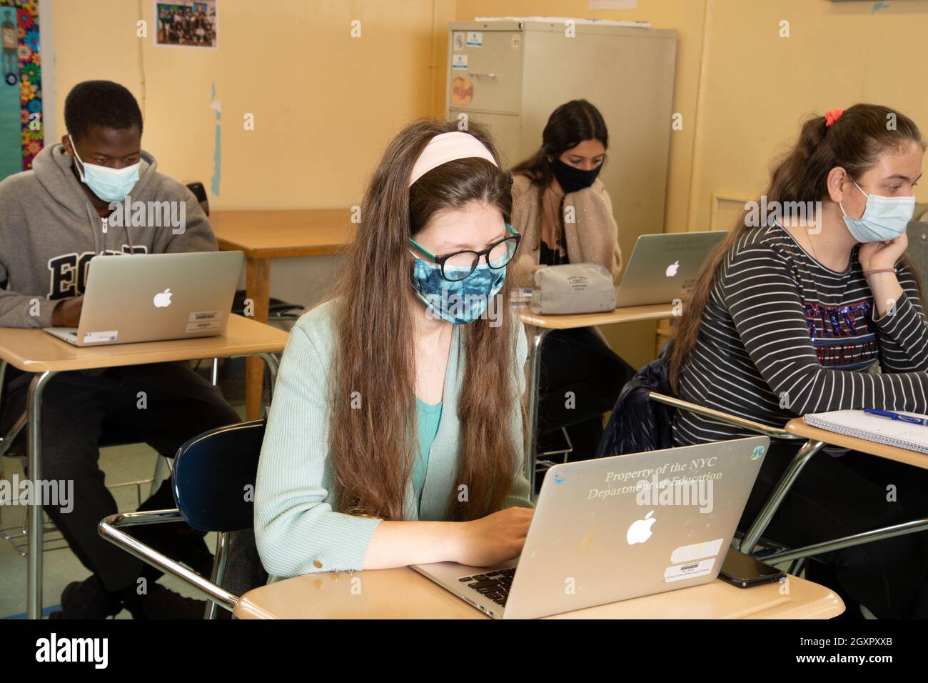 Bildung High School, Klassenzimmer Szene, Studenten bei der Arbeit an Schreibtischen mit Laptop-Computern, alle tragen Gesichtsmasken gegen Covid-19-Infektion zu schützen Stockfoto