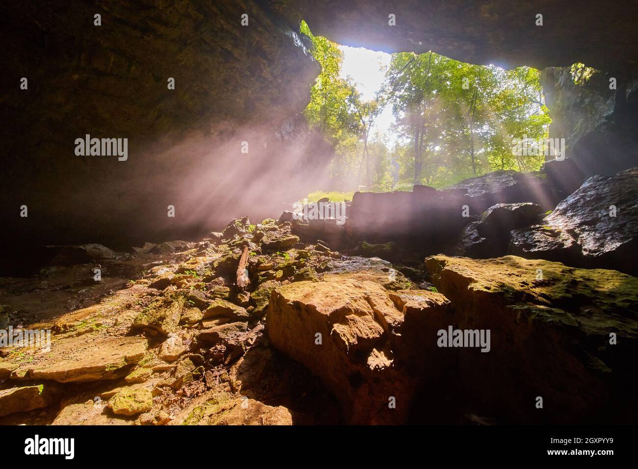 Höhlenöffnung mit Lichtstrahlen, die einleuchten Stockfoto