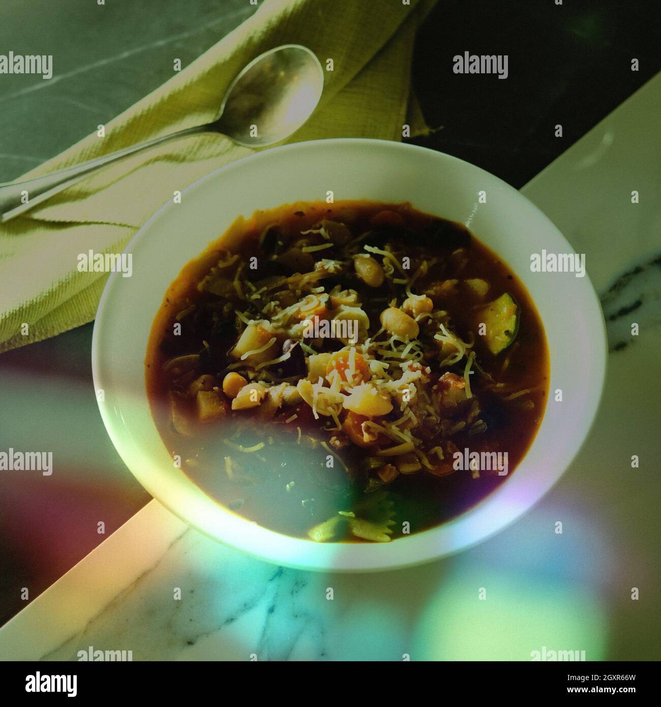 Klassische italienische Minestrone-Suppe mit Gemüsebohnen und Pfannkuchen, stilisiert, um Vintage- oder Retro-Look mit verblassten Farben, Körnung und leichtem Leck Stockfoto
