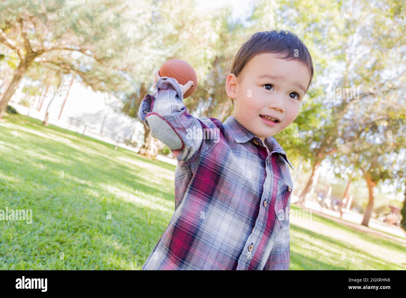 Entzückende Mischlinge Jungen spielen Fußball draußen im Park. Stockfoto