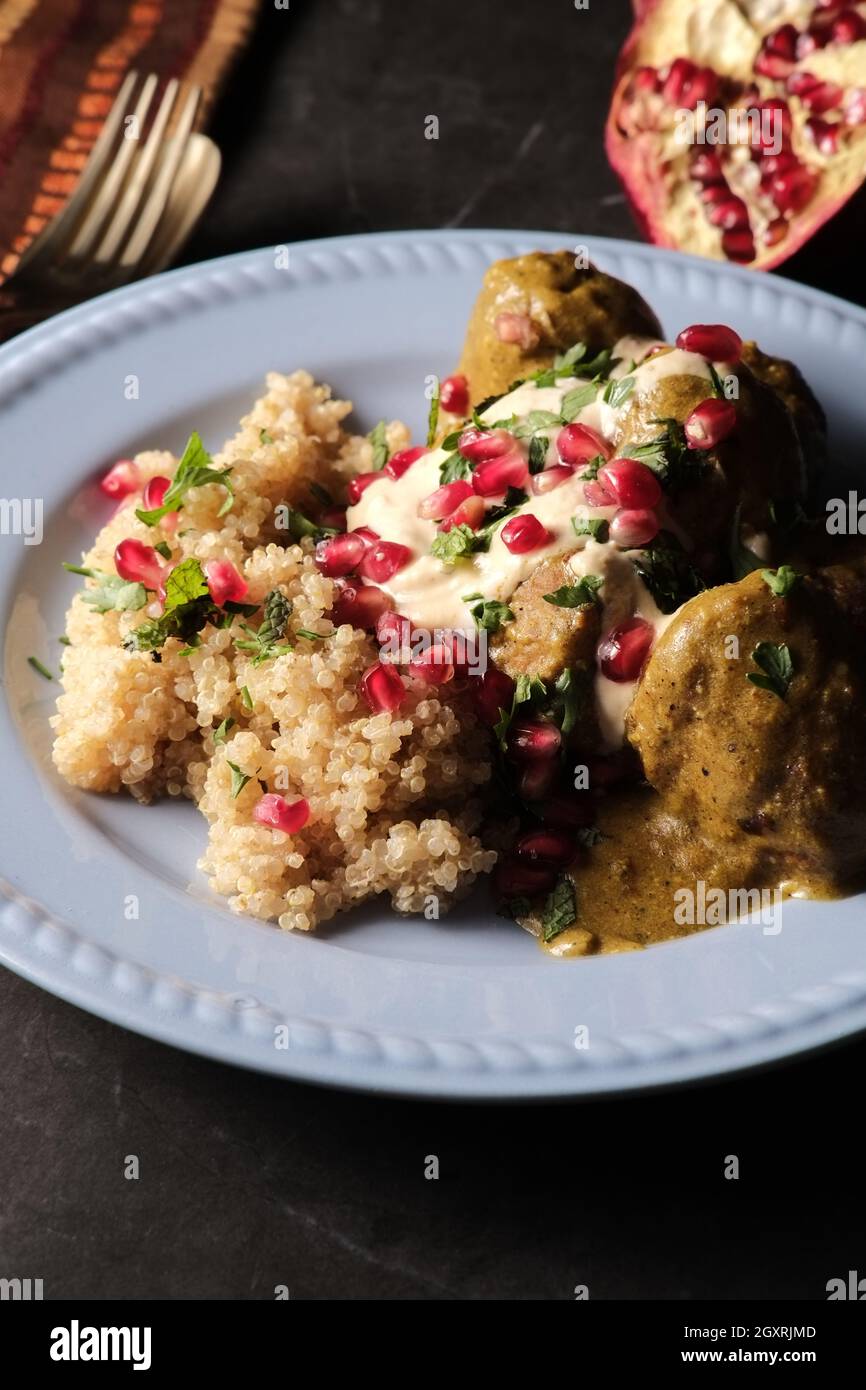 Türkische Fleischbällchen in Hummussauce mit Quinoa und Granatapfelbeeren Stockfoto