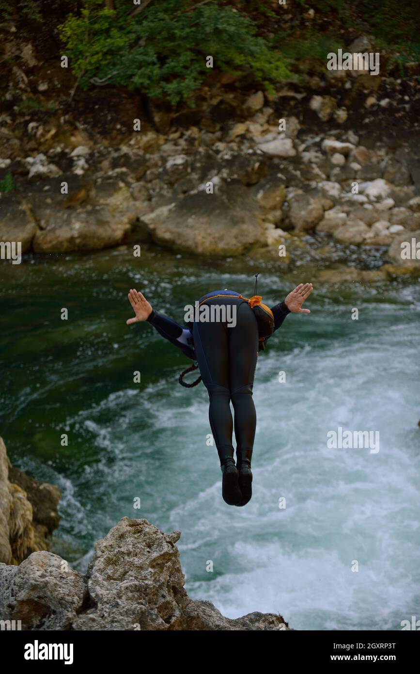 Mann, der im wilden Fluss Adrenalin springt, Sport Canyoning Stockfoto