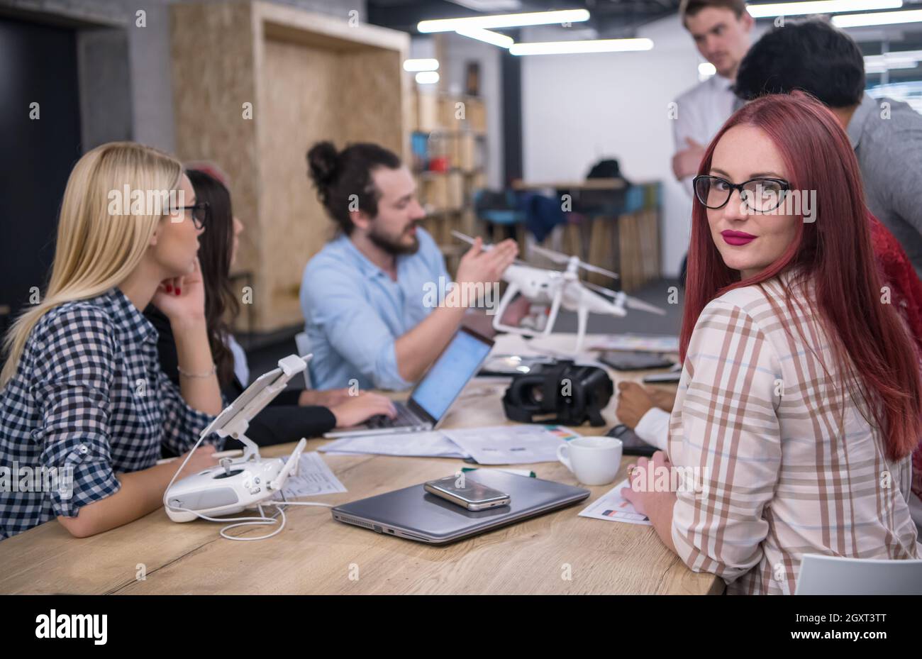 Redhead business Frau mit ihrem multiethnischen startup Business Team diskutieren neue Business Plan, die auf Notebook- und Tablet Computer beim Lernen ab Stockfoto