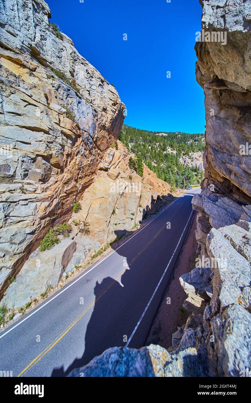 Senkrechte Straßenschnitzerei durch Bergklippen mit blauem Himmel Stockfoto