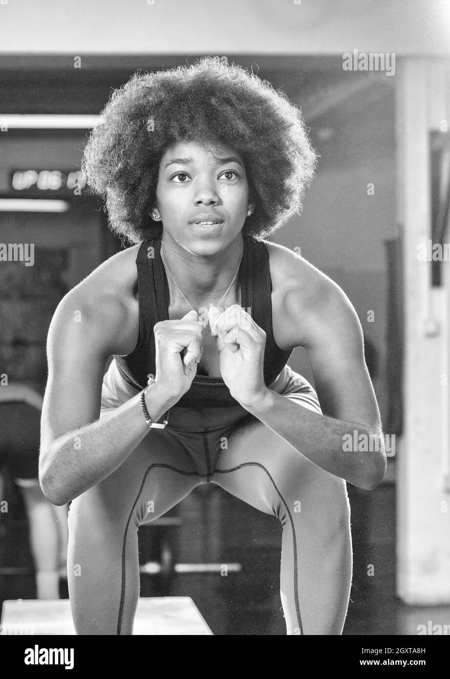 Passen Sie junge afrikanische Amerikanerin Feld springen in einem Fitnessstudio Crossfit Stil. Sportlerin ist Feld Sprünge im Fitnessstudio durchführen. Stockfoto