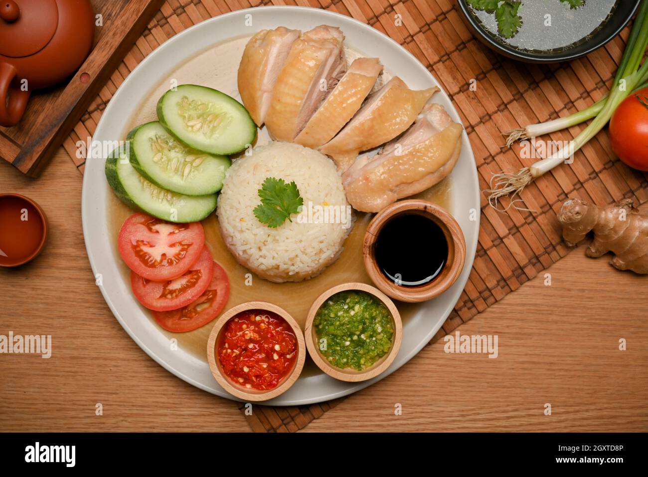 Hainanesischer Hühnerreis oder gedämpftes Huhn mit gewürztem Reis mit Chilisaucen und süßer Sojasauce Stockfoto
