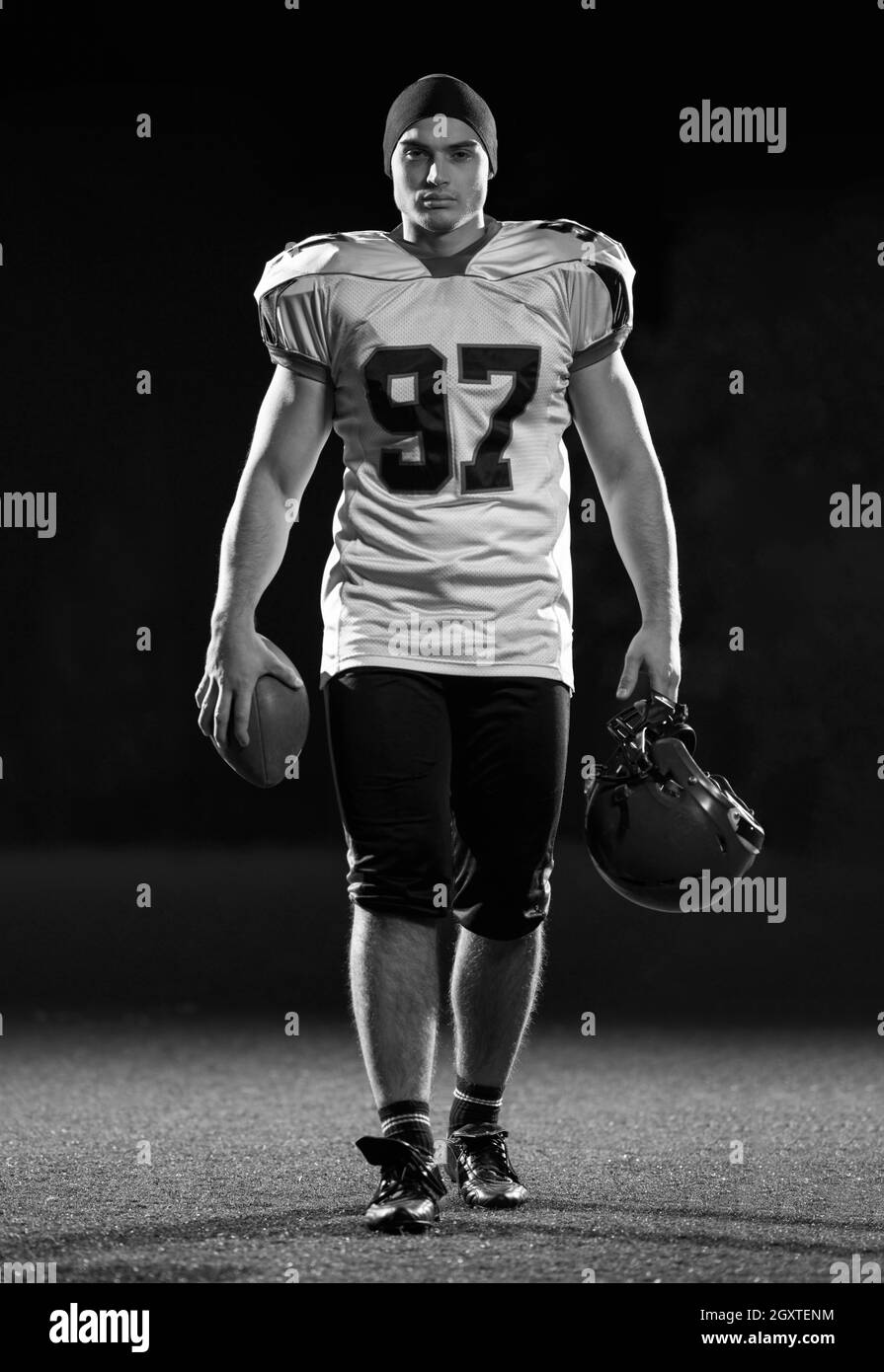 Porträt der jungen zuversichtlich American Football Spieler auf dem Feld in der Nacht Stockfoto