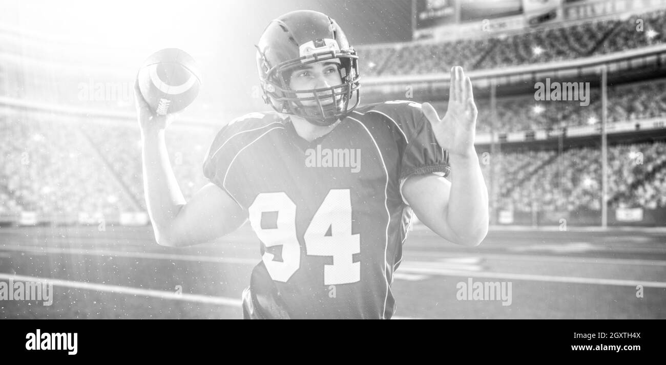 Ein quarterback American football player wirft Ball auf großen, modernen Stadion mit Lichtern und Fackeln Stockfoto