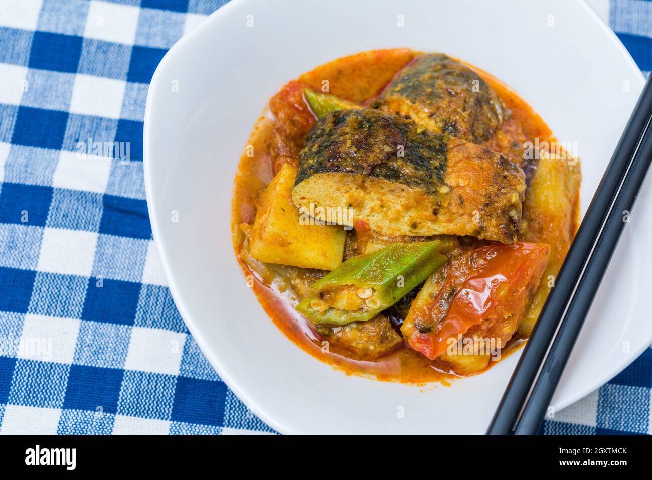 Köstliche vegetarisch-würzige Fisch-Hauptspeise auf blauem Tischtuch. Stockfoto