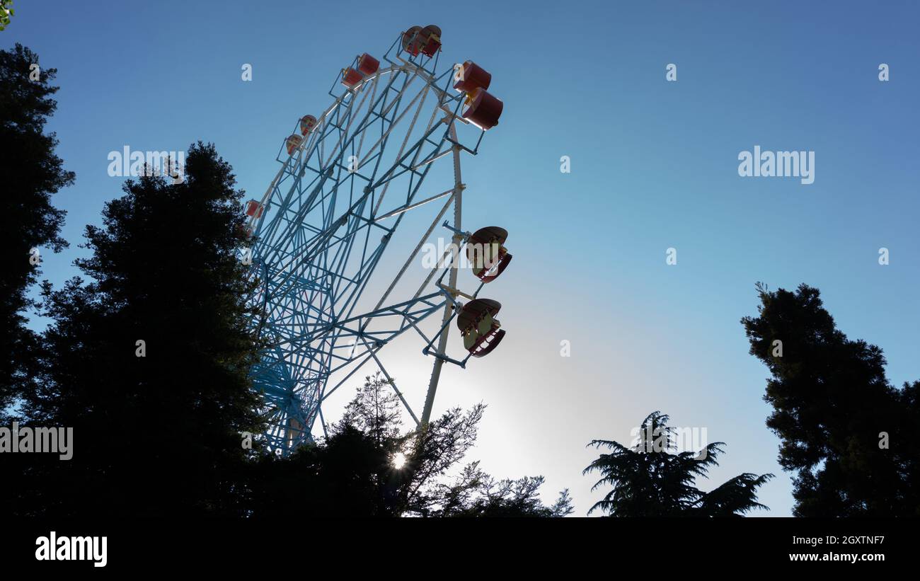Farbenfrohe Riesenräder ragen gegen den Himmel bei Sonnenuntergang. Lazarevskoje, Sotschi, Russland, auf dem Rad die Inschrift Lazarevskoe Stockfoto