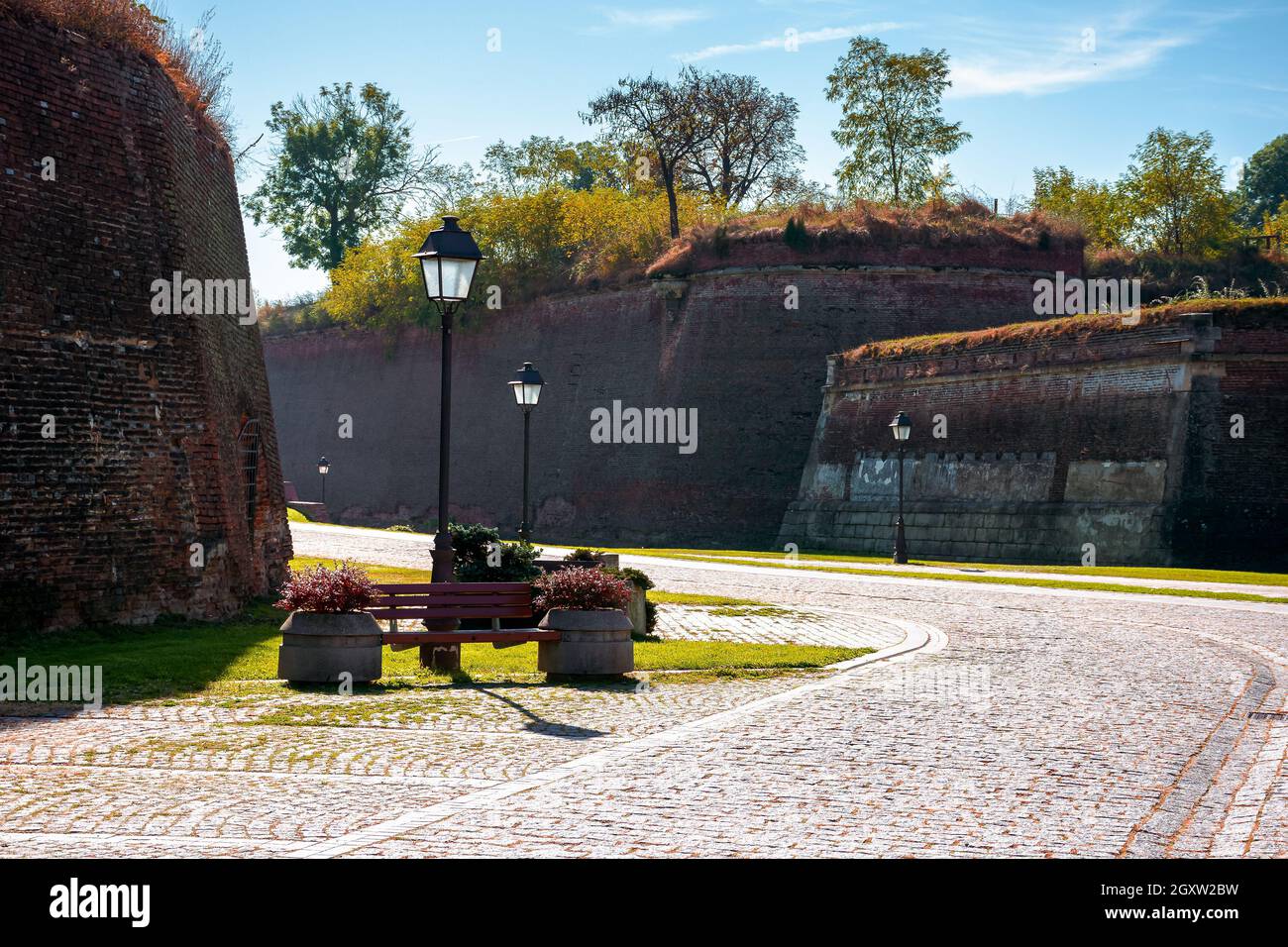 alba-iulia, rumänien - Okt 13, 2019: Innenstraßen der Zitadelle von Alba carolina im Herbst. Laternen und Bänke am Gehweg. Riesige Mauern um den Weg. Stockfoto