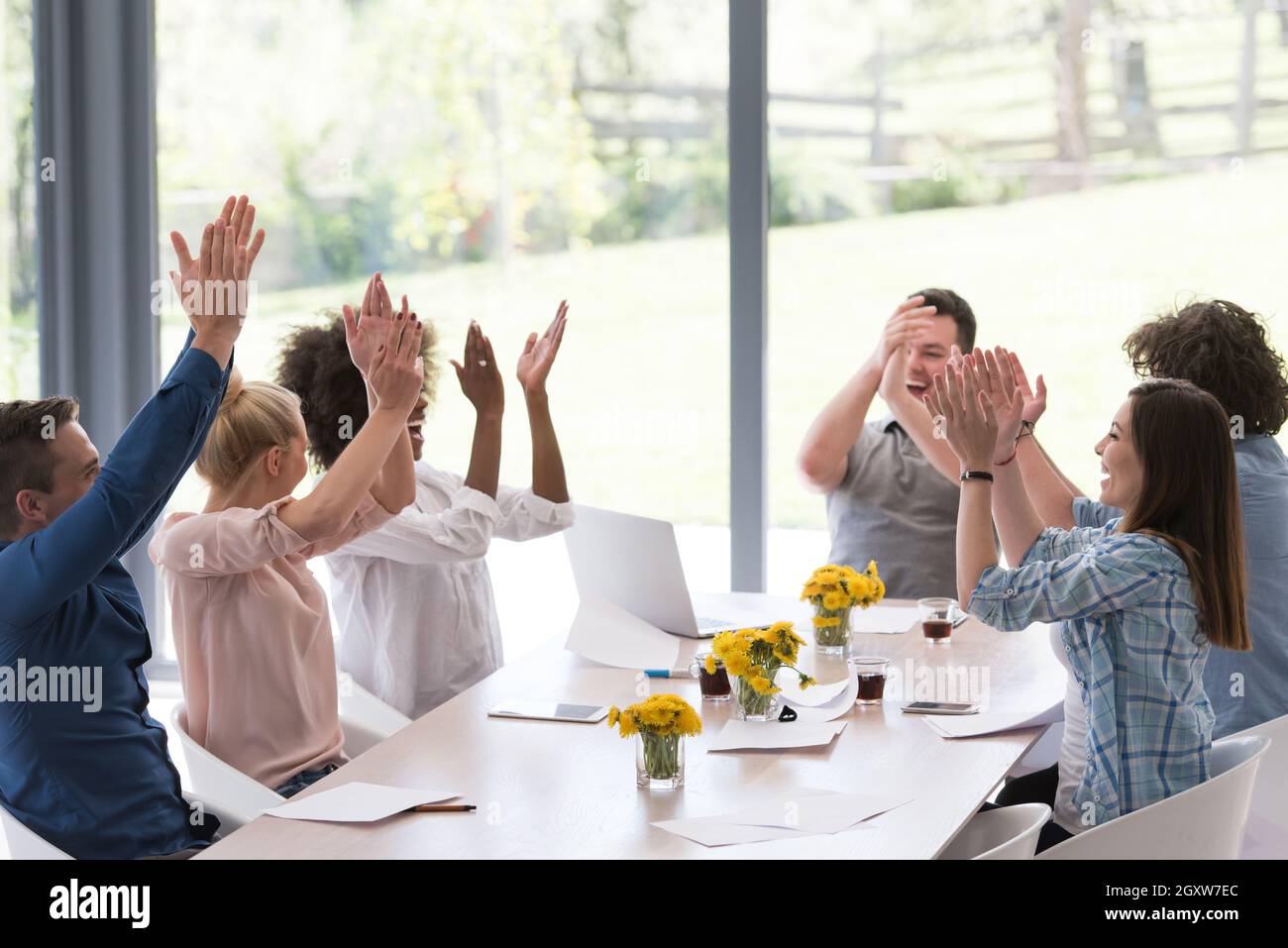 multiethnische Gruppe von jungen Geschäftsleute glücklich während feiert Erfolg an ihre Arbeitsplätze in Start-up-Büro Stockfoto