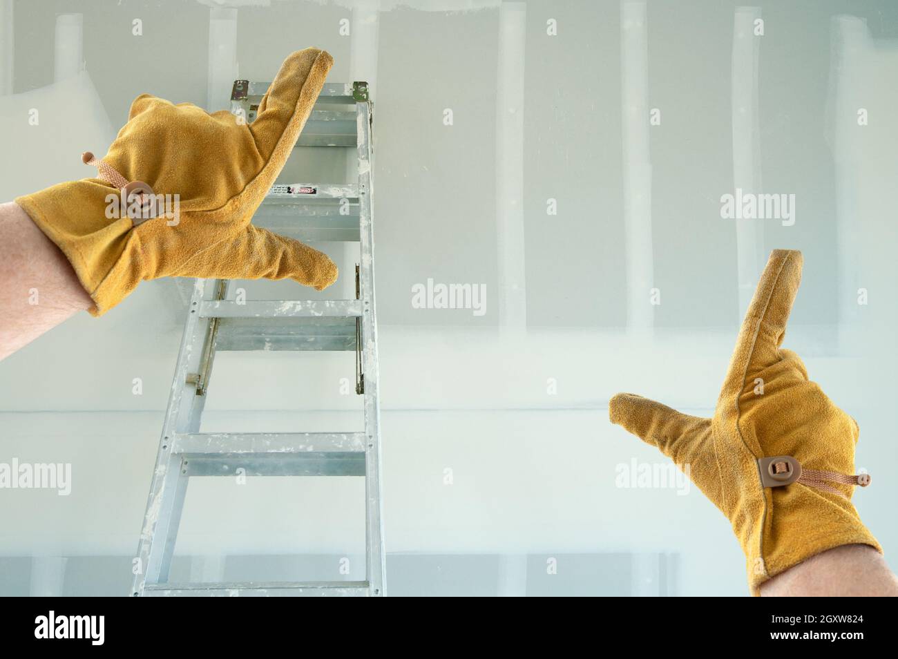 Auftragnehmer Hände in Leder Handschuhe Framing Neue leere Trockenbau. Stockfoto