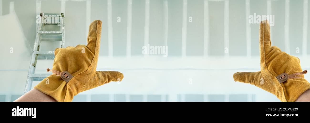 Auftragnehmer Hände in Leder Handschuhe Framing Neue leere Trockenbau. Stockfoto