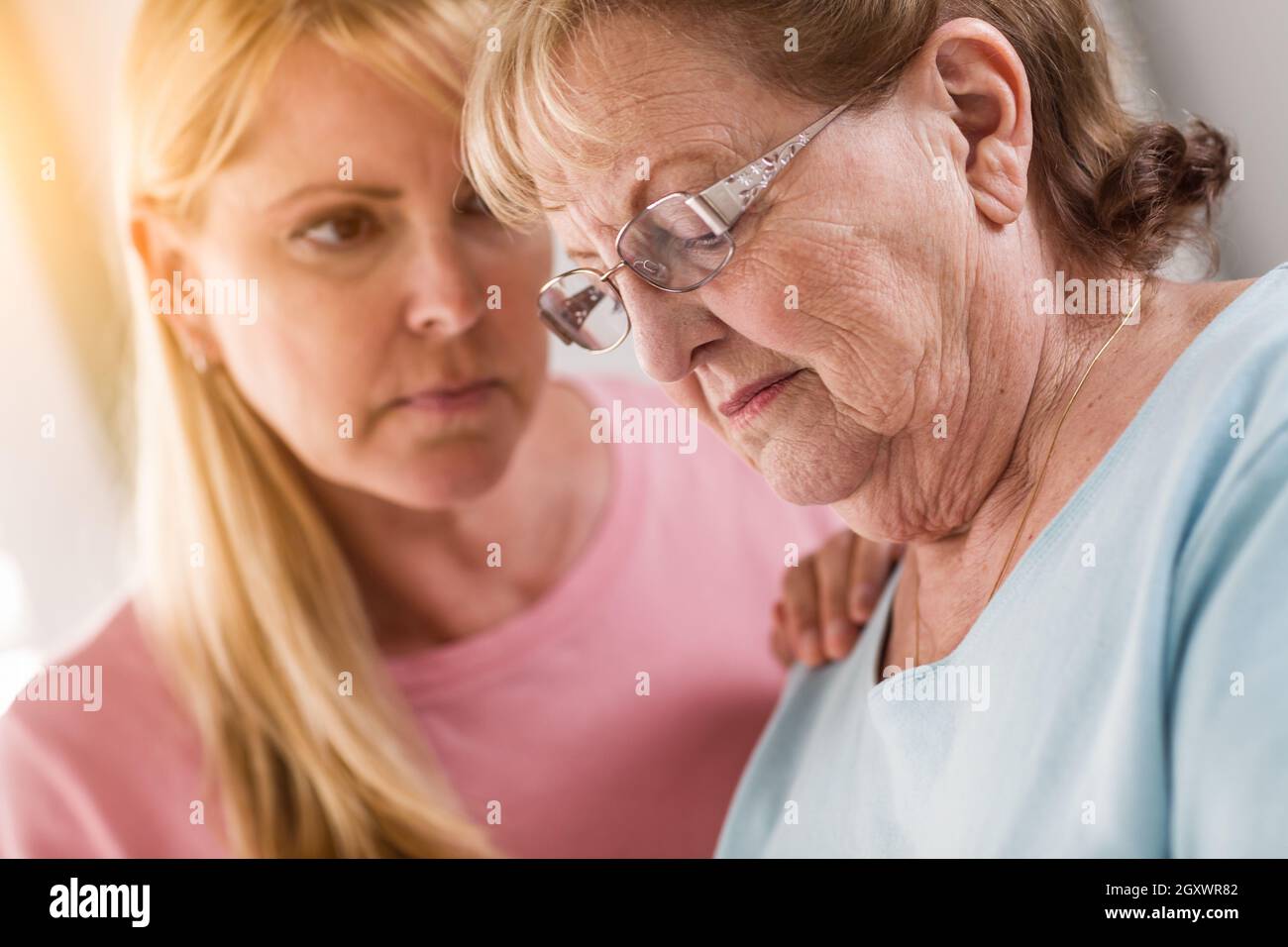 Junge Frau tröstet traurige Senior Erwachsenfrau. Stockfoto