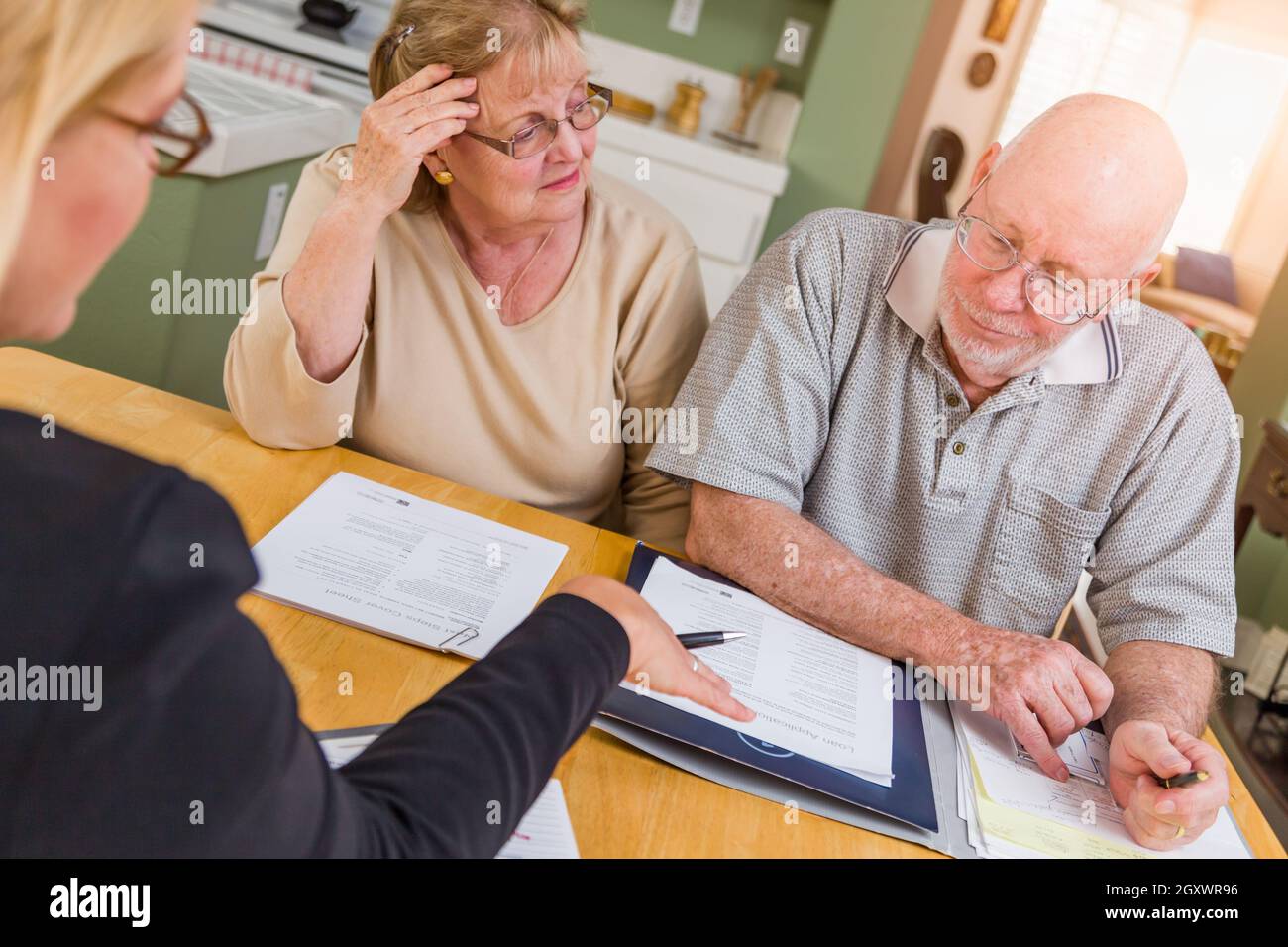 Senior nach Paar über Dokumente in Ihrem Haus mit Agenten zu signieren. Stockfoto