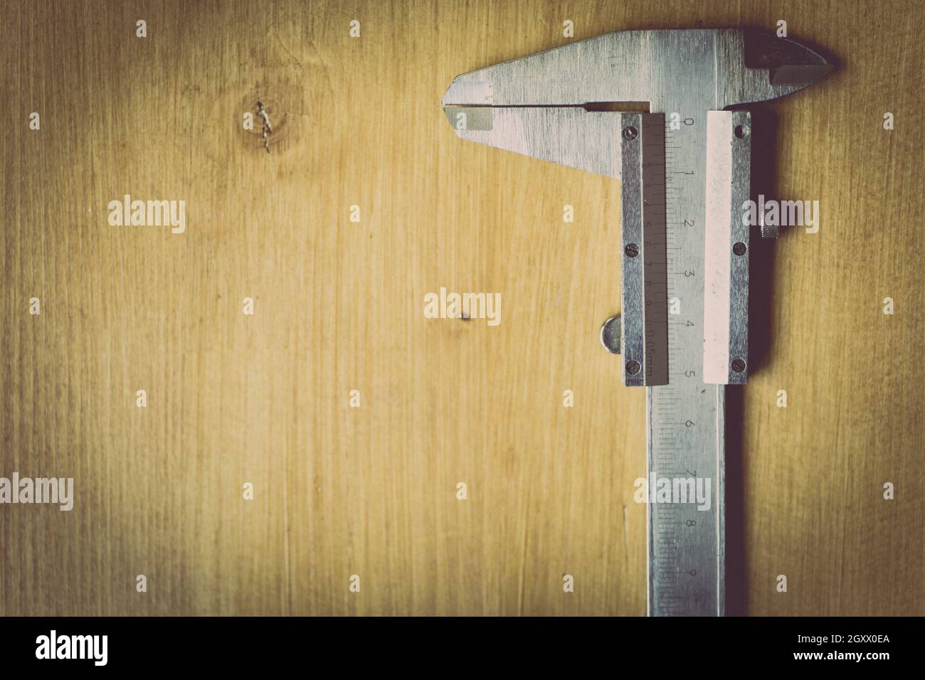 Nahaufnahme eines Messers mit Vernier auf einem Holzhintergrund. Stockfoto