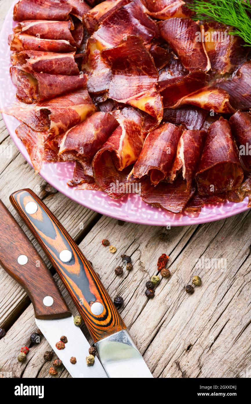 Geschnittenes basturma oder Fleisch ruckig. Rindfleisch ruckig, getrocknetes Rindfleisch auf dem Teller. Armenisches Essen Stockfoto