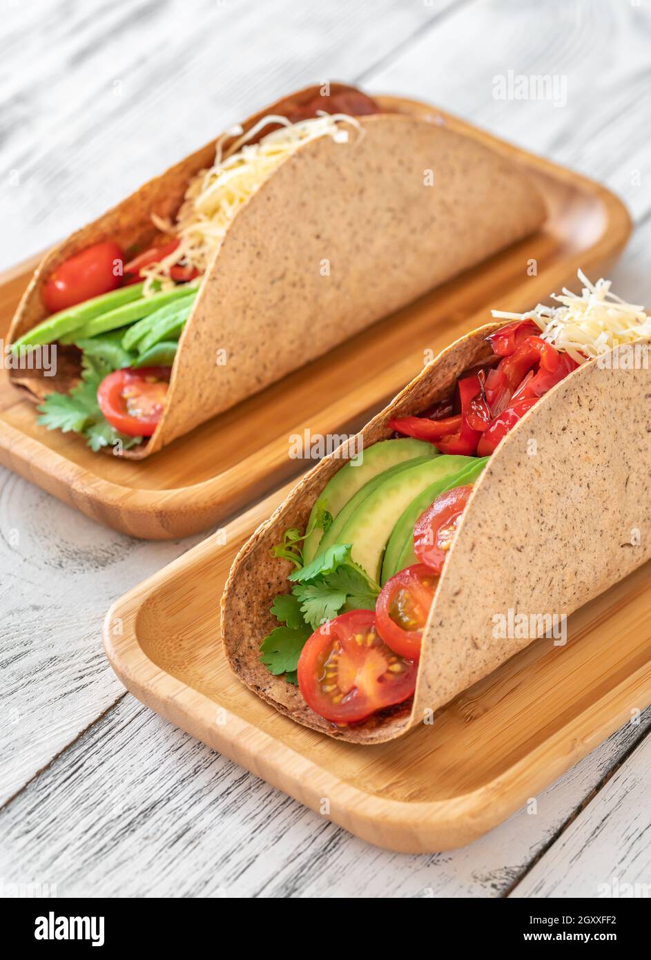 Tacos mit Schinken und Gemüse auf dem servierten Holzteller Stockfoto
