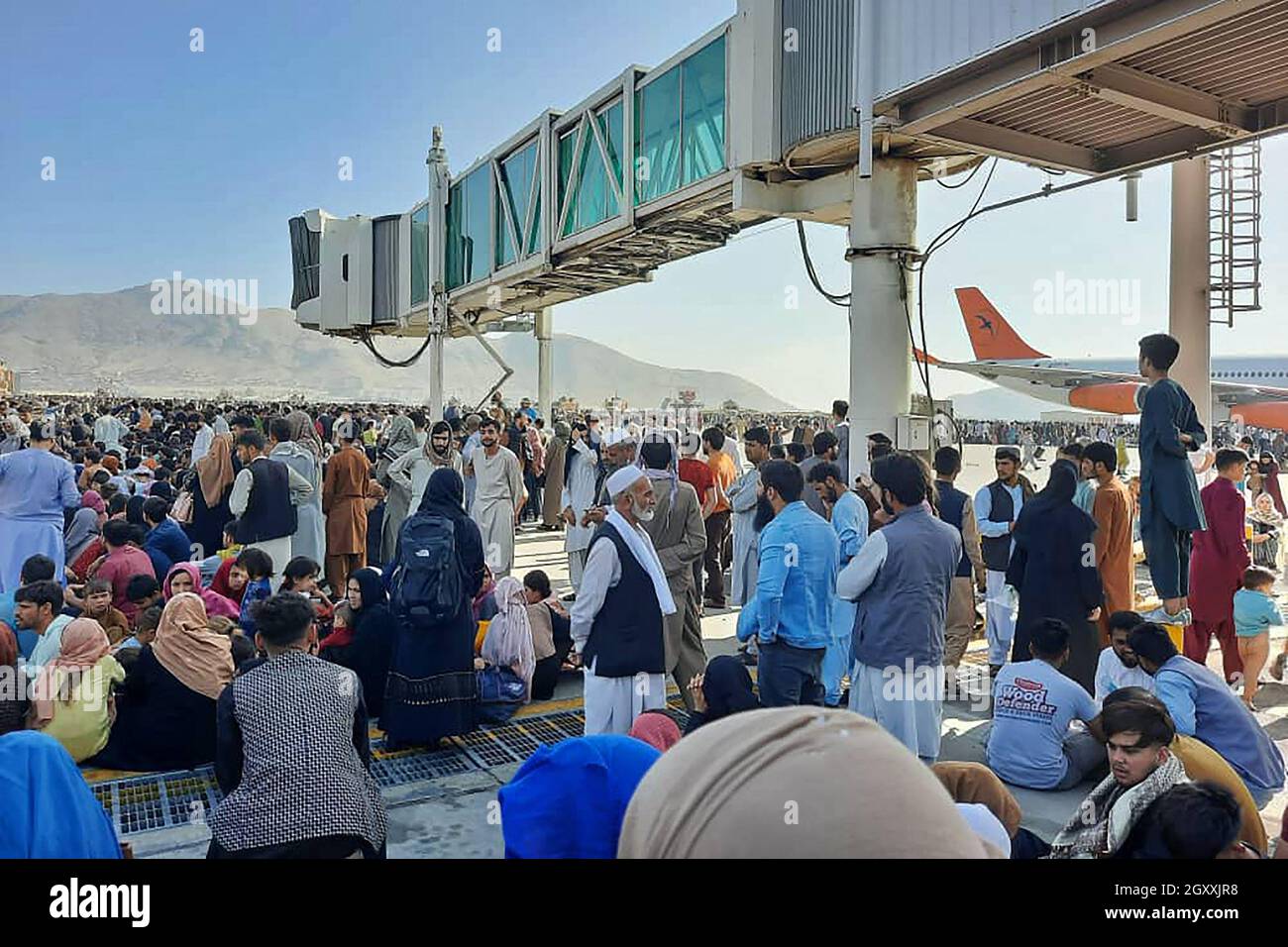 Afghanen drängen sich am 16. August 2021 auf dem Asphalt des Flughafens von Kabul, um aus dem Land zu fliehen, während die Taliban Afghanistan unter Kontrolle hatten. Stockfoto