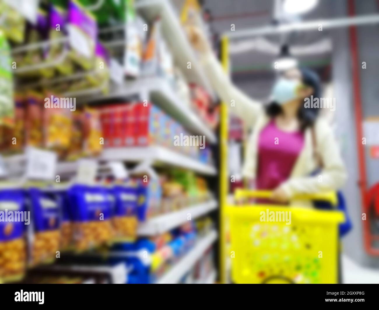 Verschwommene Bilder eines asiatischen Mädchens, das wegen des Corona-Virus Covid-19 in einem Supermarkt einkauft. Geschäfts- und Gesundheitskonzept. Stockfoto