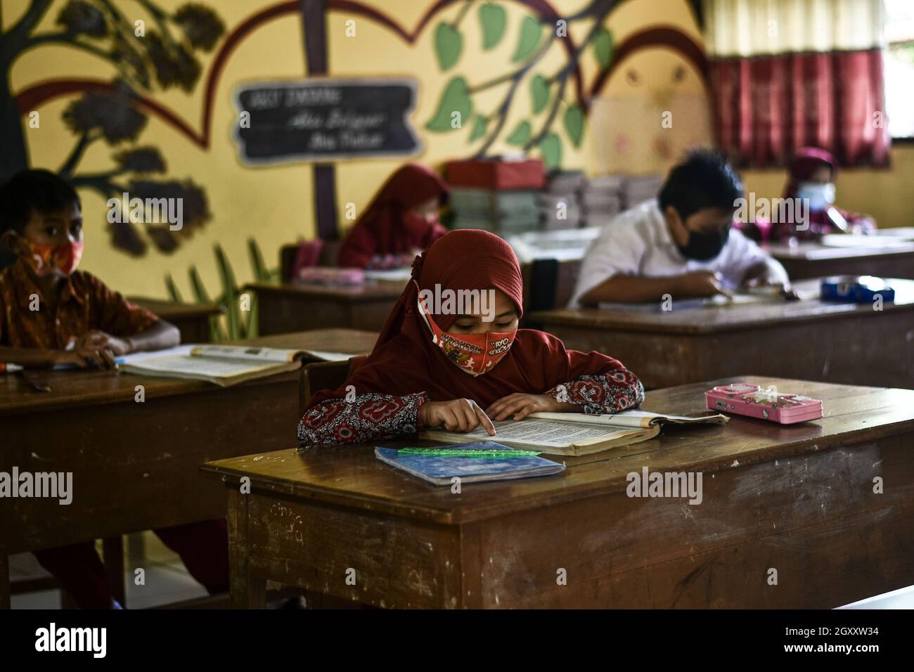 Soppeng, Indonesien. Oktober 2021. Die Schüler nehmen an der persönlichen Lernschule in Soppeng Regency Teil, indem sie sehr strenge Gesundheitsprotokolle implementieren. Wie von der indonesischen Regierung durch das Bildungs- und Kulturbüro empfohlen, z. B. Einhaltung eines Mindestabstands von 1.5 Metern, Verwendung von Masken, Händewaschen und Einführung eines Schichtsystems, das 50 % der Höchstgrenze pro Klasse beträgt. (Foto von Moch Farabi Wardana/Pacific Press) Quelle: Pacific Press Media Production Corp./Alamy Live News Stockfoto