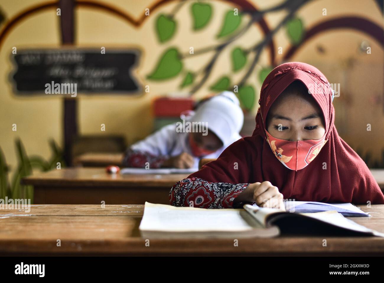 Soppeng, Indonesien. Oktober 2021. Die Schüler nehmen an der persönlichen Lernschule in Soppeng Regency Teil, indem sie sehr strenge Gesundheitsprotokolle implementieren. Wie von der indonesischen Regierung durch das Bildungs- und Kulturbüro empfohlen, z. B. Einhaltung eines Mindestabstands von 1.5 Metern, Verwendung von Masken, Händewaschen und Einführung eines Schichtsystems, das 50 % der Höchstgrenze pro Klasse beträgt. (Foto von Moch Farabi Wardana/Pacific Press) Quelle: Pacific Press Media Production Corp./Alamy Live News Stockfoto