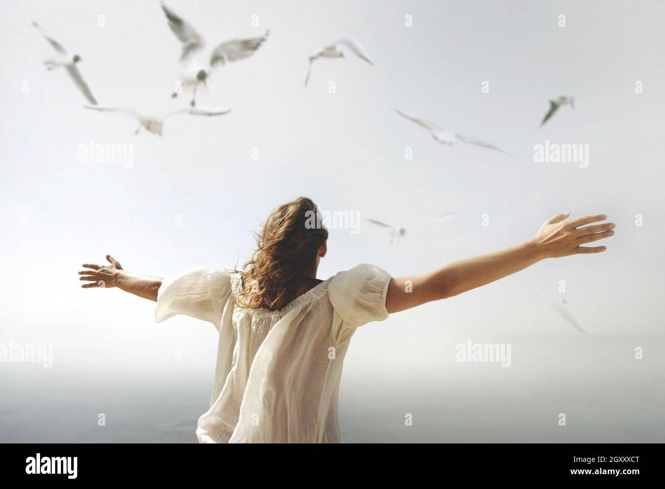 Frau mit offenen Armen zum Himmel hin atmet eine Luft der Freiheit Stockfoto