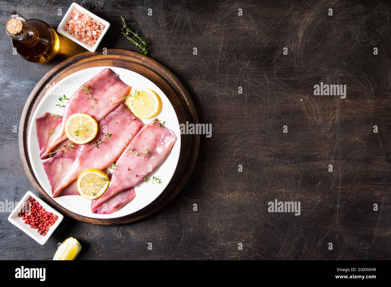 Frische Tintenfische oder Tintenfische für gekochte Speisen. Frischer roher Tintenfisch. Roher Tintenfisch mit Zitrone. Draufsicht und Kopierbereich für Ihren Text Stockfoto