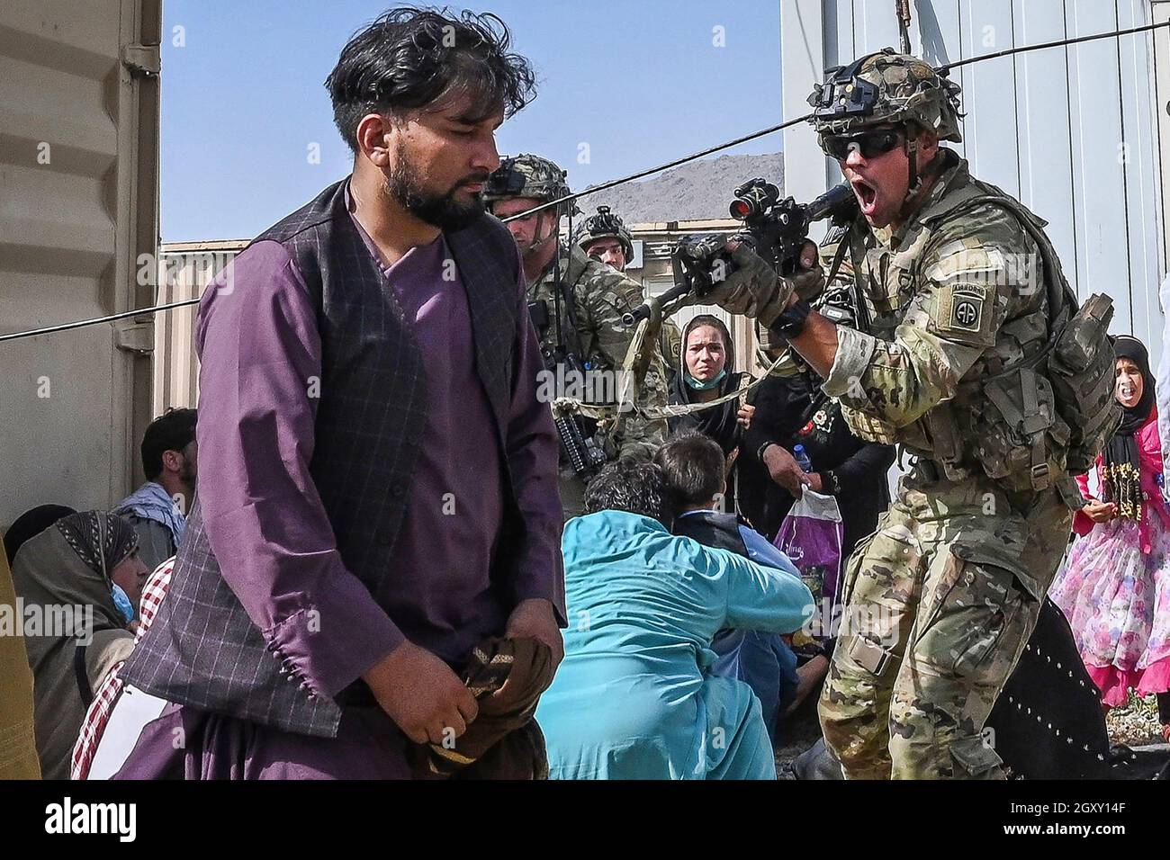 US-Soldat richten seine Waffe am 16. August 2021 auf einen afghanischen Passagier am Flughafen Kabul in Kabul, nach einem erstaunlich schnellen Ende der 2 in Afghanistan Stockfoto