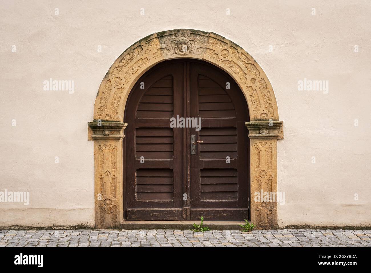 Eine alte gewölbte, doppelflügelige Tür. Stockfoto